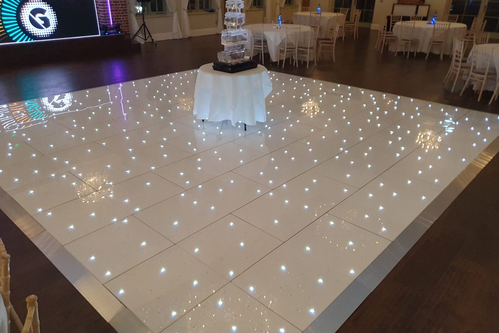 LED Starlit dancefloor at a manor house reception, with an ice sculpture centrepiece